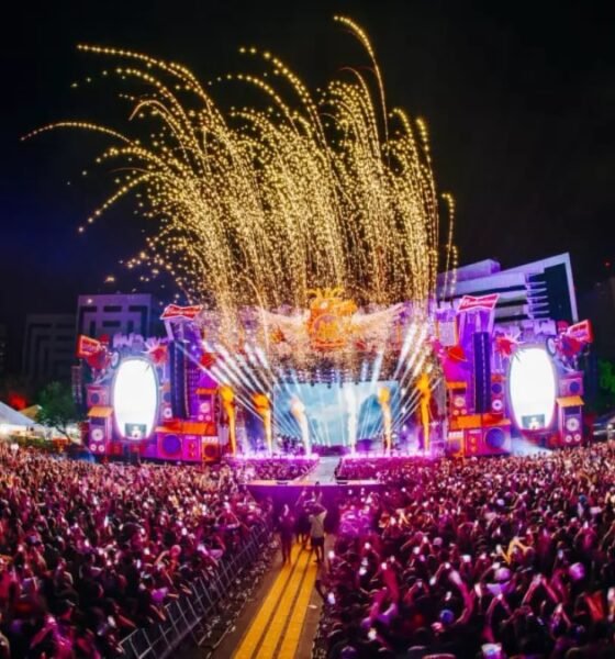 Público lota o Rap In Cena 2025 no Parque Harmonia, em Porto Alegre, com palco iluminado e fogos durante o festival.