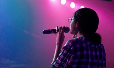 Mulher com microfone em apresentação de rap representa o evento Elas na Batalha em Goiânia