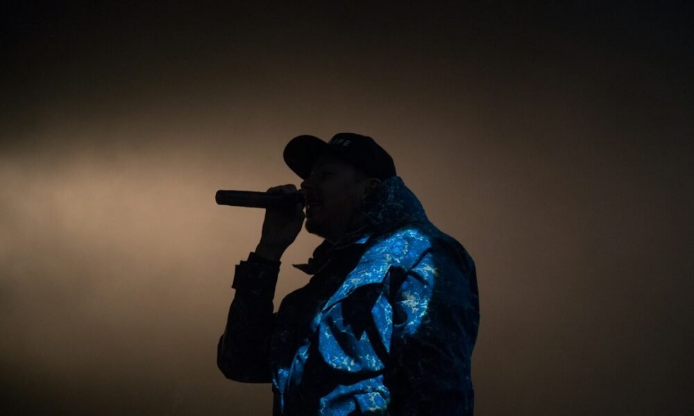 Rapper se apresenta ao microfone em um palco