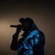 Rapper se apresenta ao microfone em um palco