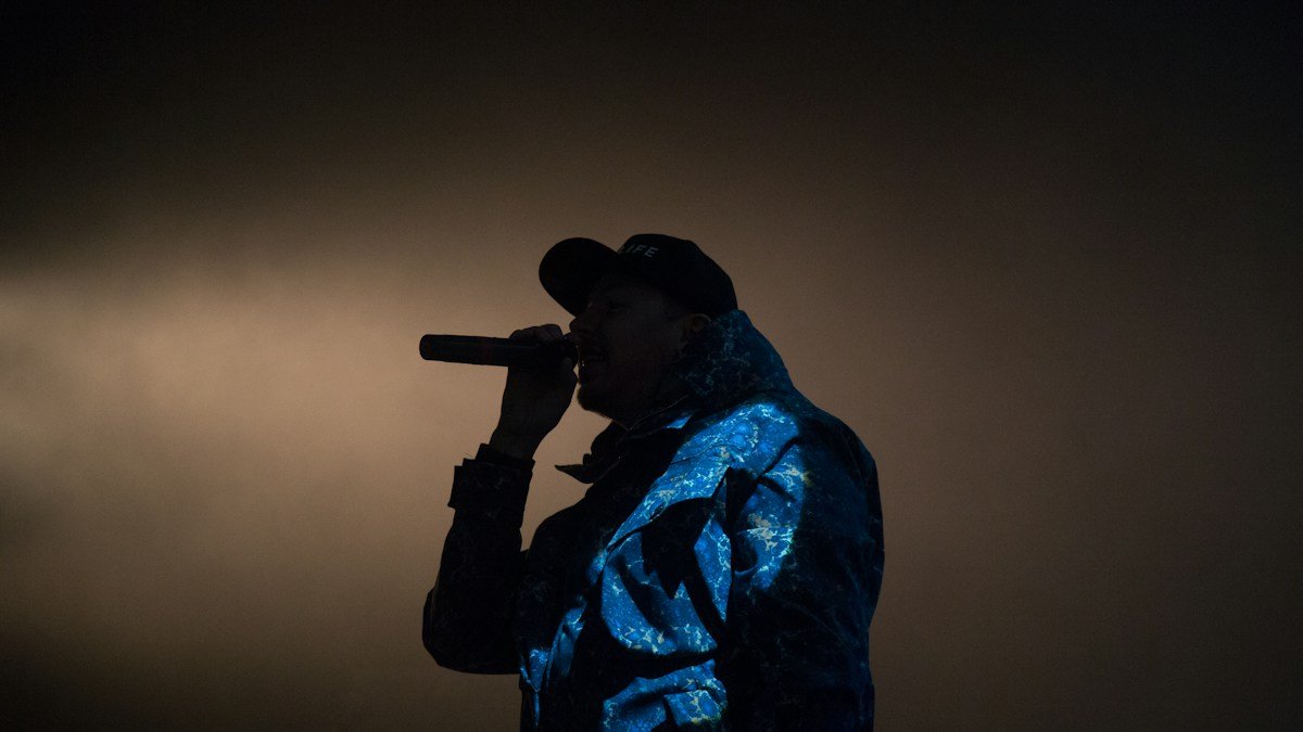 Rapper se apresenta ao microfone em um palco