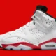Tênis Air Jordan 6 Infrared branco com detalhes vermelhos e pretos sobre fundo vermelho