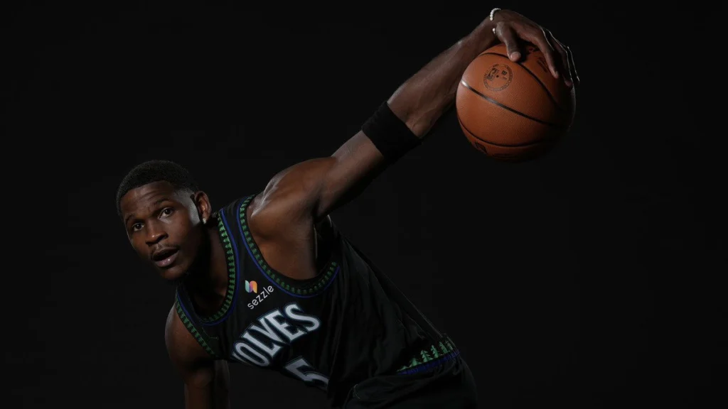 Anthony Edwards com o uniforme do Minnesota Timberwolves segura a bola em ensaio de estúdio