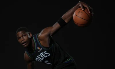 Anthony Edwards com o uniforme do Minnesota Timberwolves segura a bola em ensaio de estúdio