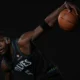 Anthony Edwards com o uniforme do Minnesota Timberwolves segura a bola em ensaio de estúdio
