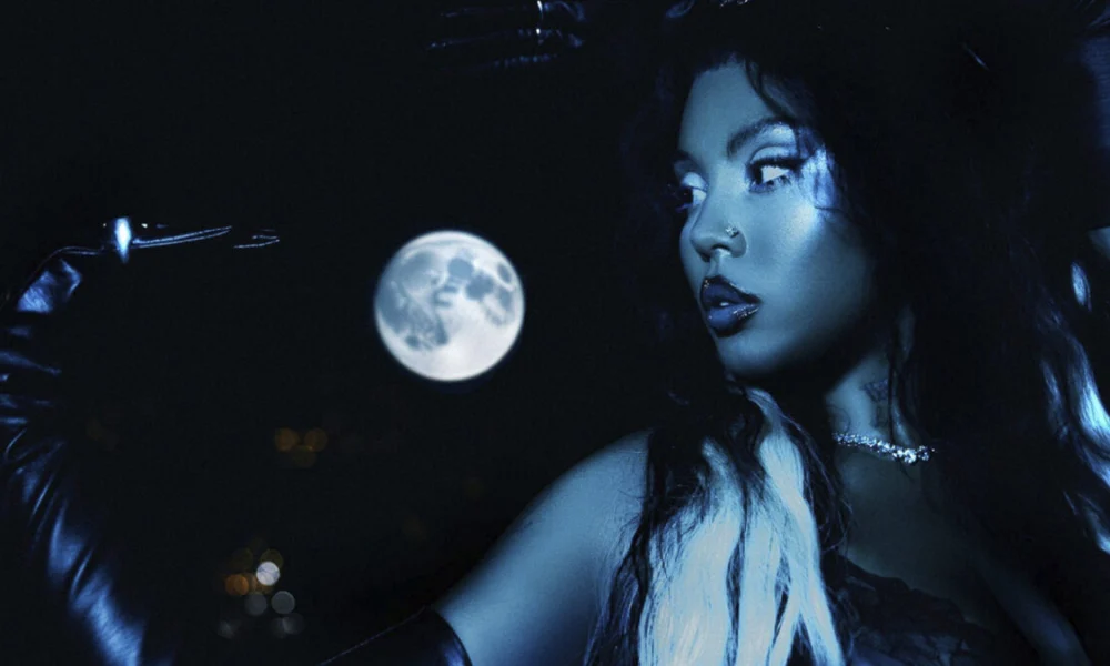 BUDAH em foto de divulgação do álbum Frequência Lunar, com luva preta e a lua cheia ao fundo