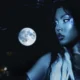 BUDAH em foto de divulgação do álbum Frequência Lunar, com luva preta e a lua cheia ao fundo