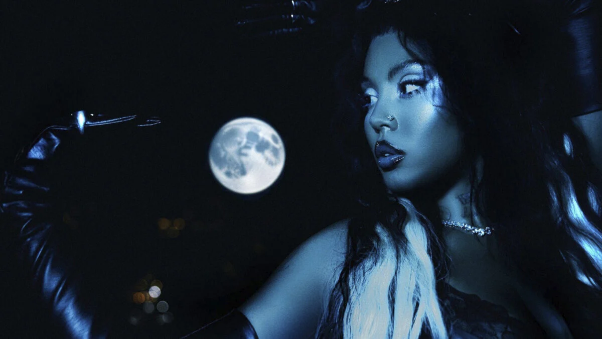 BUDAH em foto de divulgação do álbum Frequência Lunar, com luva preta e a lua cheia ao fundo