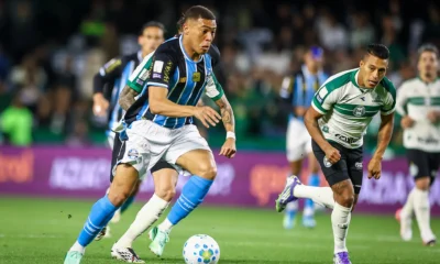 Jogador do Grêmio conduz a bola marcado por atleta do Coritiba no Couto Pereira