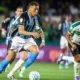 Jogador do Grêmio conduz a bola marcado por atleta do Coritiba no Couto Pereira