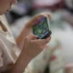 Mãos de criança segurando smartphone, imagem ilustrativa