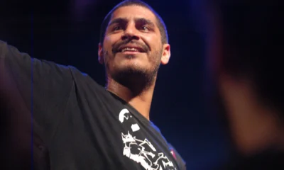 Criolo sorri no palco com o braço erguido em show de dezembro de 2010, época de Nó na Orelha