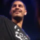 Criolo sorri no palco com o braço erguido em show de dezembro de 2010, época de Nó na Orelha