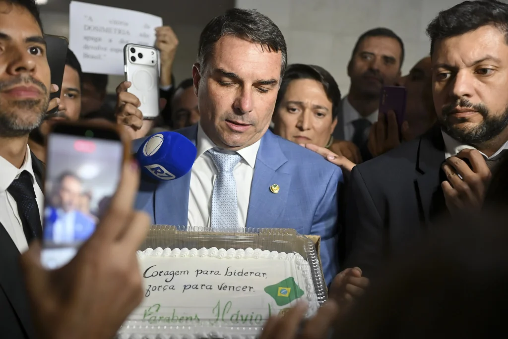 Flávio Bolsonaro cercado de jornalistas e celulares em entrevista no Senado