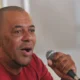 O rapper GOG, de camiseta vermelha, fala ao microfone em debate em Brasília