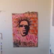 Painel grafitado com o rosto de Sabotage fixado em parede de corredor