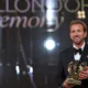 Harry Kane de smoking segura o troféu da Bola de Ouro 2026 no palco do Palladium, em Londres