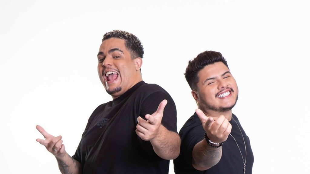 Igão e Mítico do Podpah lado a lado em imagem promocional de divulgação, fotografados diante de fundo claro.