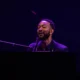 John Legend canta ao piano sob luz roxa no Montreux Jazz Festival de 2026