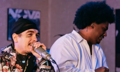 LEALL, de camisa branca, ao lado de Sain, que canta ao microfone, na gravação do SALA da Podpah Records