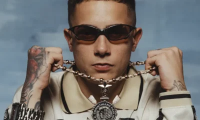 MC Hariel de óculos escuros segura corrente com pingente em foto de divulgação do novo EP