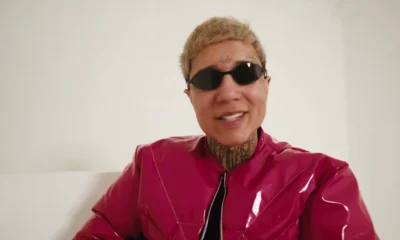 Massaru de óculos escuros e jaqueta vermelha em cena do clipe de Obito