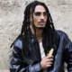 Matuê Rabanne: o rapper de jaqueta de couro segura o frasco do perfume 1 Million Black