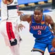 Shai Gilgeous-Alexander com o uniforme azul do Oklahoma City Thunder conduzindo a bola em jogo da NBA
