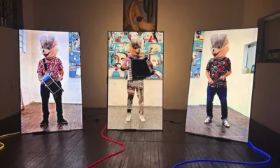 Exposição A Tela Que Habito: instalação de Tec com telas verticais e figuras mascaradas no ateliê na Barra Funda