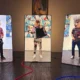 Exposição A Tela Que Habito: instalação de Tec com telas verticais e figuras mascaradas no ateliê na Barra Funda