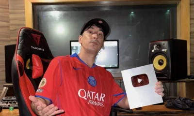 Tiankris sentado em cadeira gamer no estúdio da CMK Beats, segurando a placa de prata do YouTube