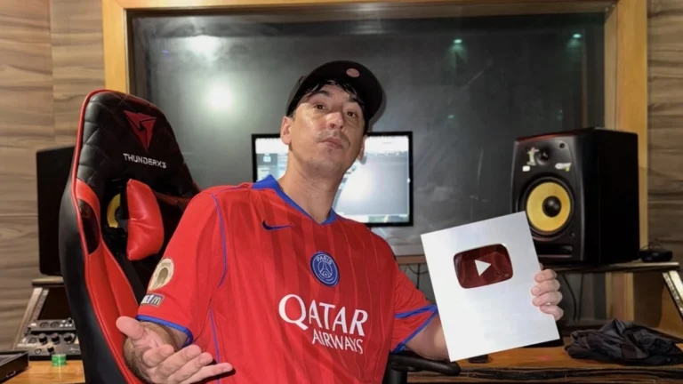Tiankris sentado em cadeira gamer no estúdio da CMK Beats, segurando a placa de prata do YouTube