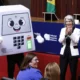 Mascote da urna eletrônica e público em evento dos 30 anos da urna no TSE