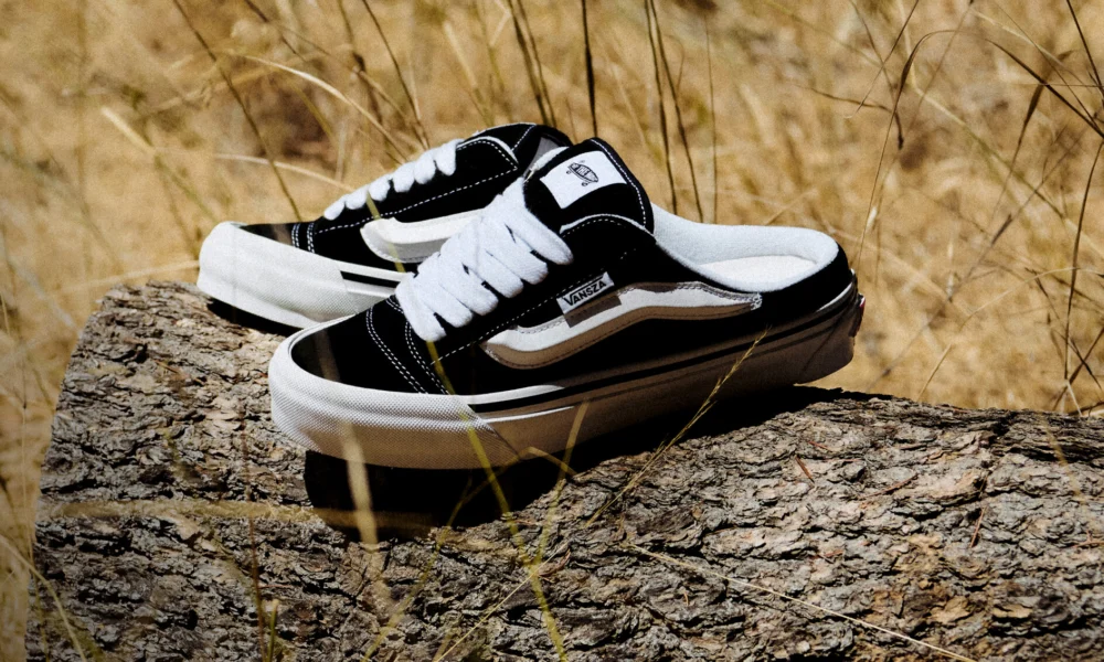 Tênis Vans Knu Skool Mule da coleção VANSZA, em preto e branco, apoiado num tronco ao ar livre