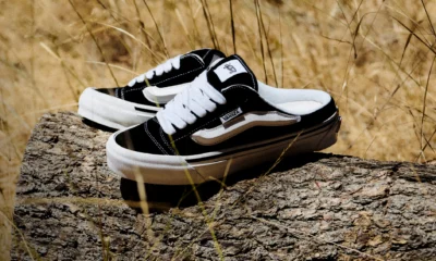 Tênis Vans Knu Skool Mule da coleção VANSZA, em preto e branco, apoiado num tronco ao ar livre